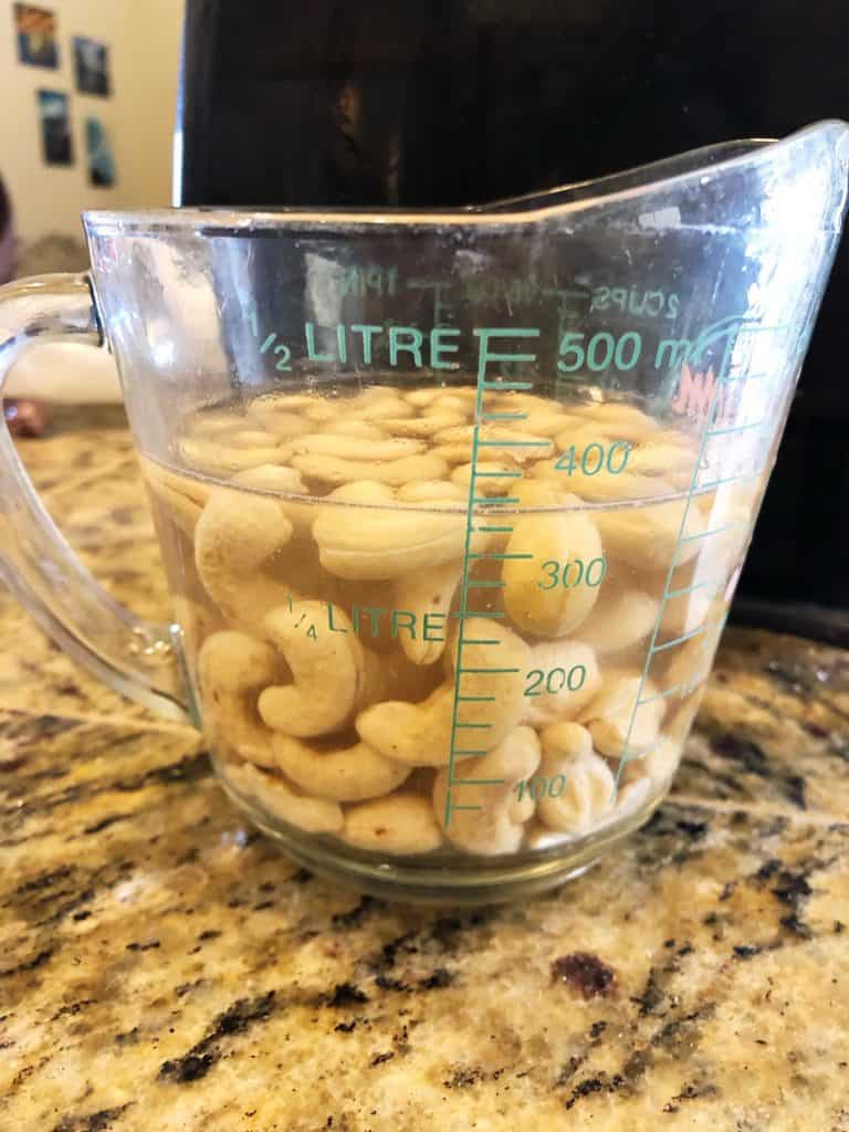 cashews soaking in measuring cup