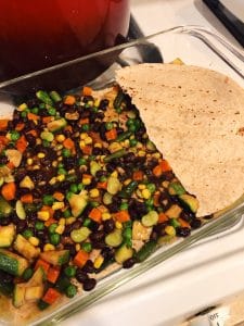Tortillas and vegetables layered in the pan for Mexican Casserole