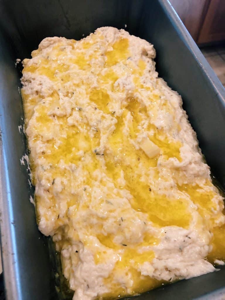 butter on top of the raw batter in the loaf pan for garlic herb beer bread