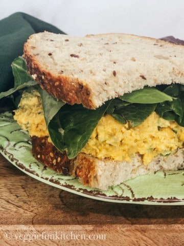 vegan egg salad sandwich on green plate
