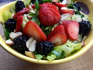 berry salad with almonds in yellow dish