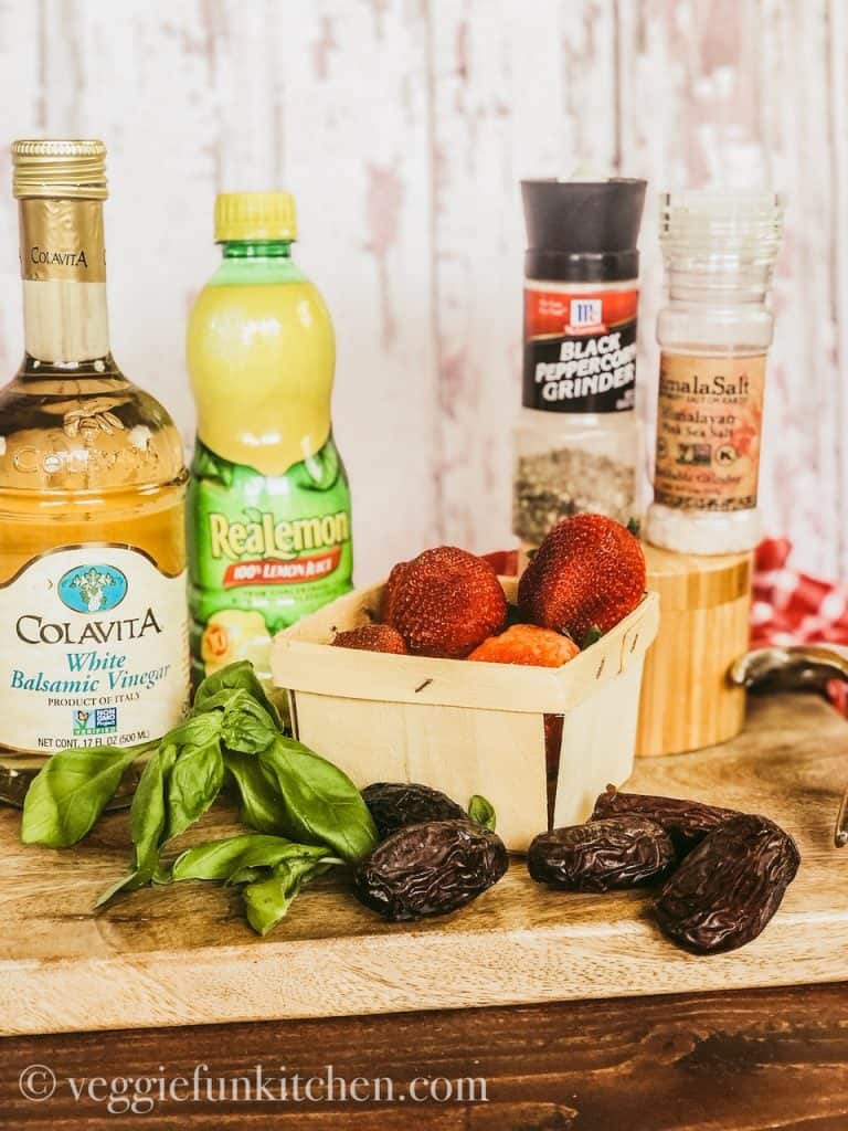 ingredients for strawberry balsamic dressing - vinegar, lemon juice, strawberries, basil, dates