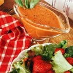 strawberry balsamic dressing in cup with strawberry salad