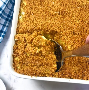 vegan funeral potatoes in white casserole dish with blue checked napkin