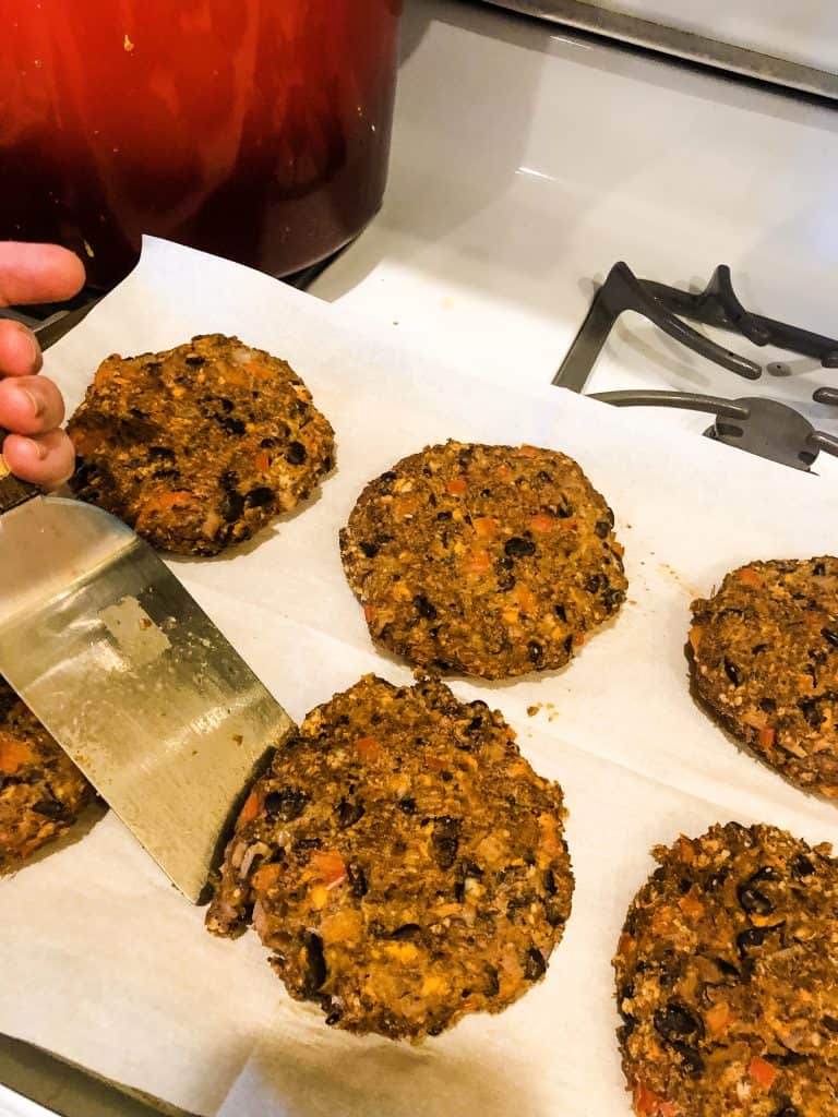Sweet potato black bean burgers being lifted with a spatula