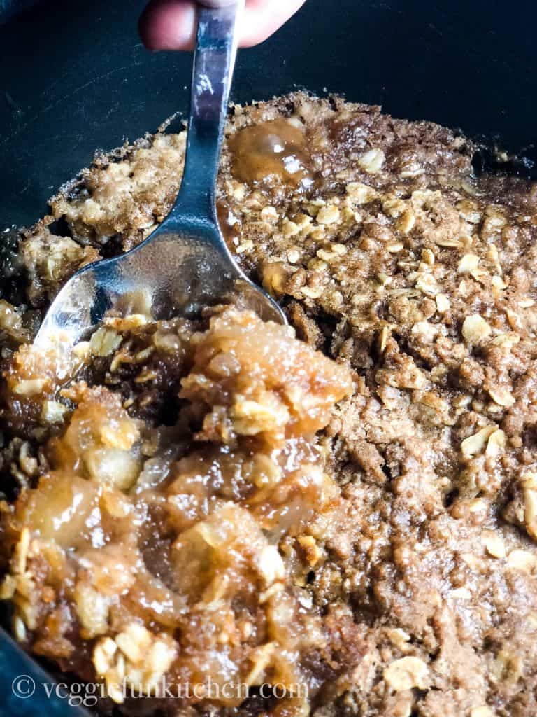 Spooning out cooked apple spice dump cake (in crockpot)