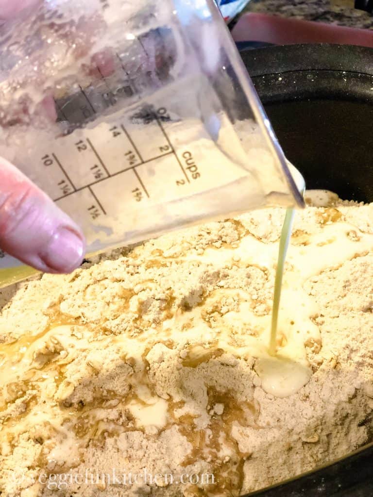 melted vegan butter being poured on top of dry cake mix