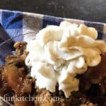Coconut milk whipped topping over apple dessert with blue checkered cloth