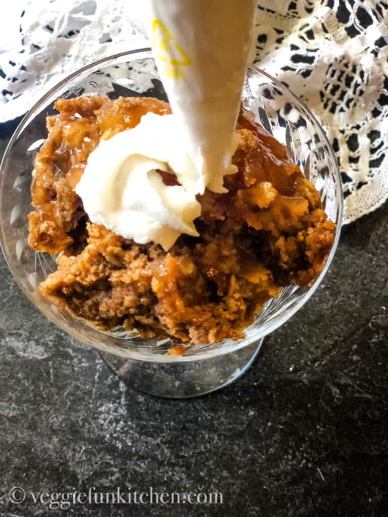 Applying whipped topping on apple dessert with pastry bag