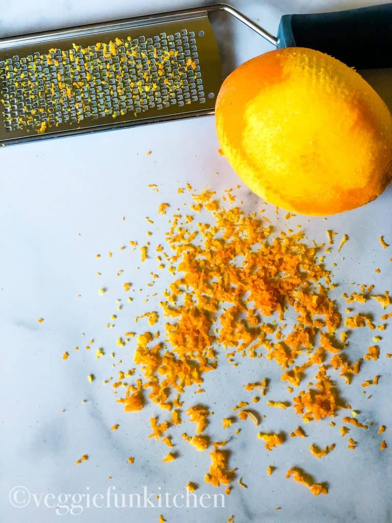 orange zest with orange and zester in background