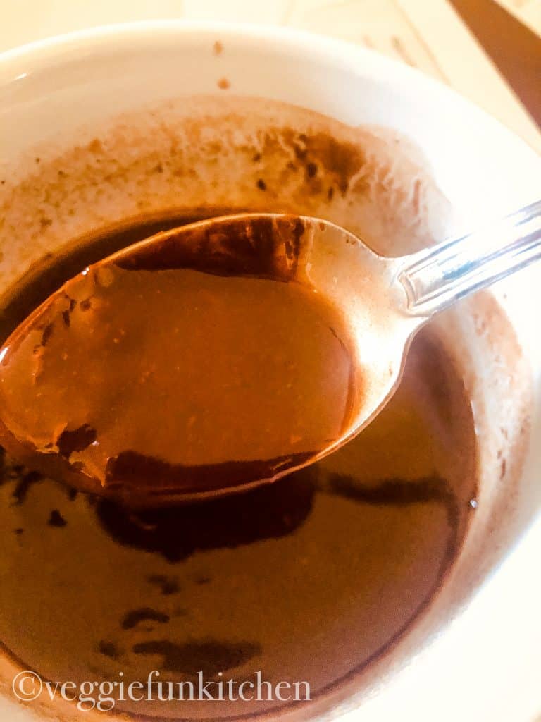 melted vegan butter and chocolate chips in bowl with spoon