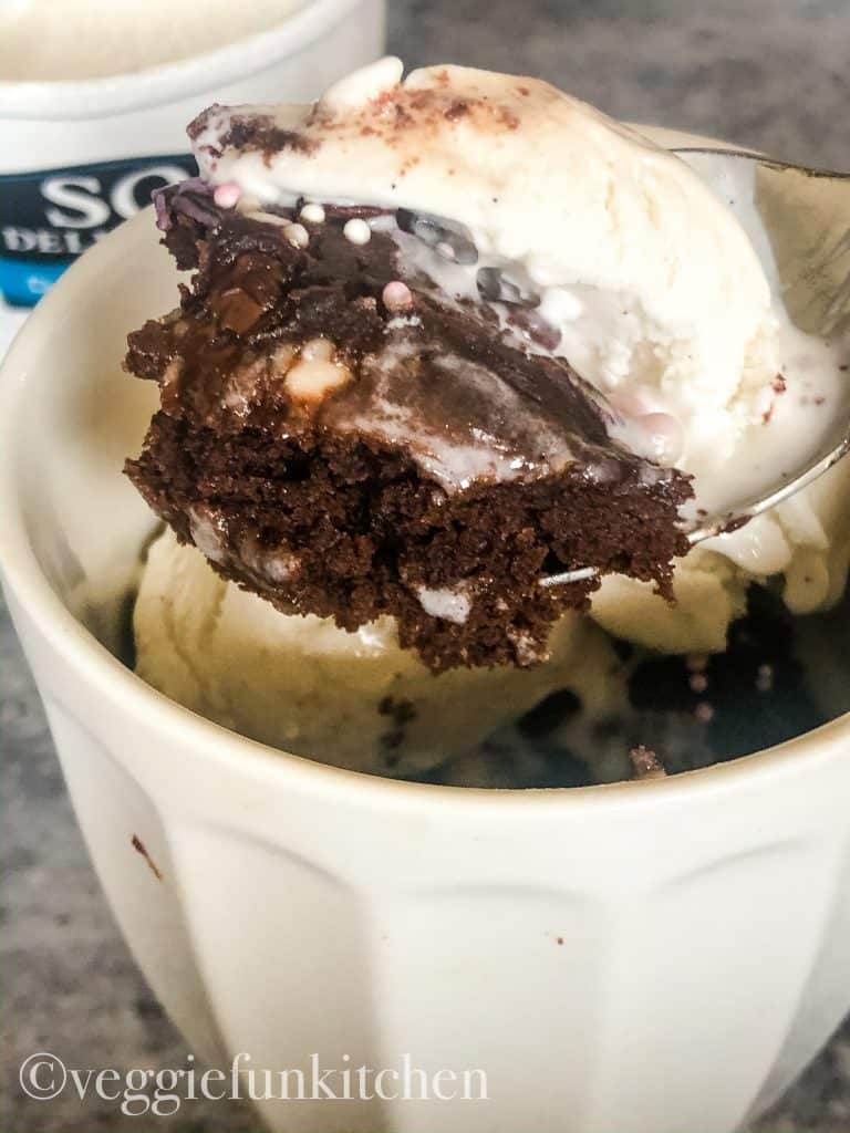spoonful of mug brownie with icecream on top