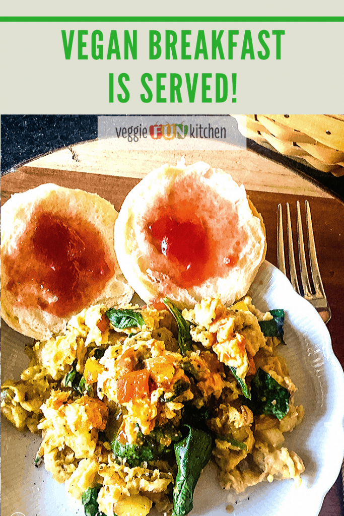 vegan breakfast scramble on plate with jammed biscuits on wooden platter with text overlay