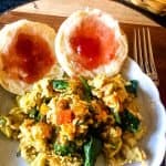 vegan breakfast scramble on plate with jammed biscuits on wooden platter