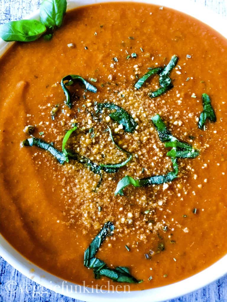 tomato soup with parm cheese and sliced basil on top