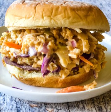 bbq chickpea salad sandwich with bun on white plate