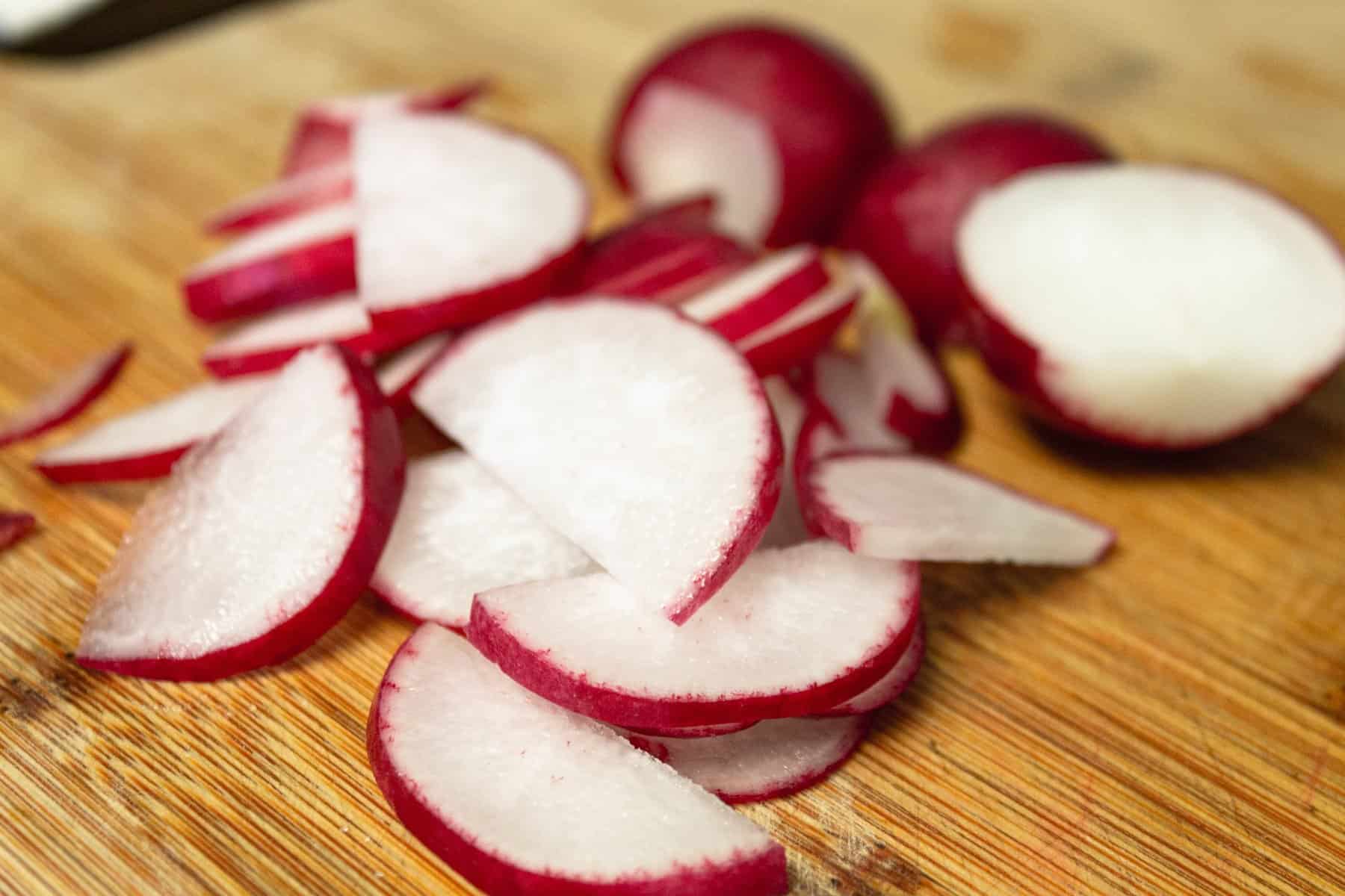 sliced radishes on wooden cutting board