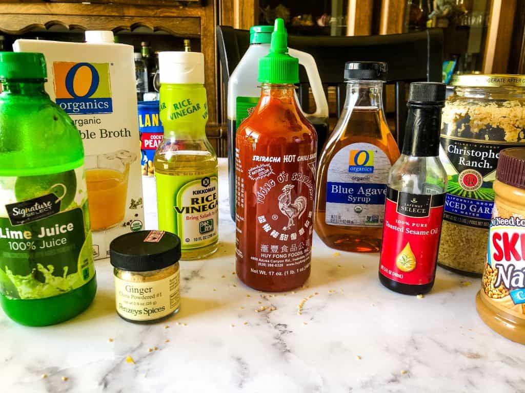 ingredients for sauce including lime juice, ginger, veggie broth, soy sauce, sriracha, agave, sesame oil, garlic, and peanut butter