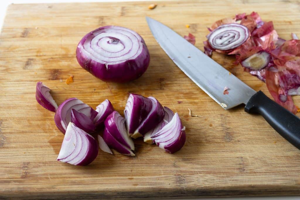 red onion being cut in rounds then in chunks