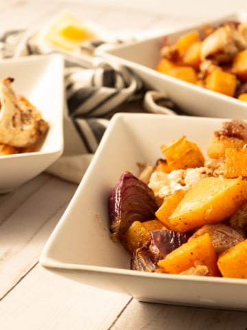 roasted butternut squash and cauliflower in white square dishes