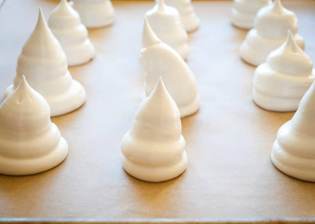 pan of vegan meringues in the shape of ghosts ready to put in the oven