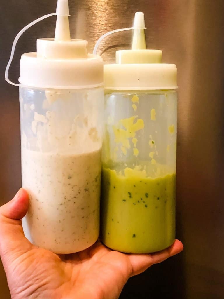 two plastic squeeze bottles - one with jalapeno ranch dressing and the other with creamy avocado sauce