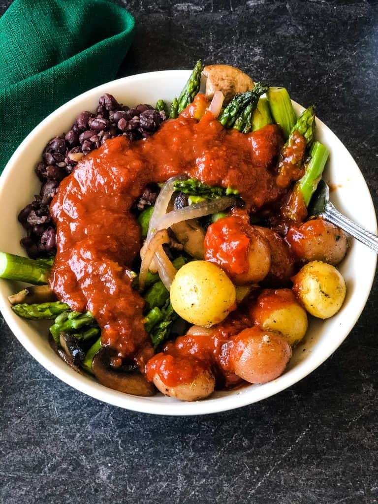 bowl of veggies and beans topped with bbq sauce