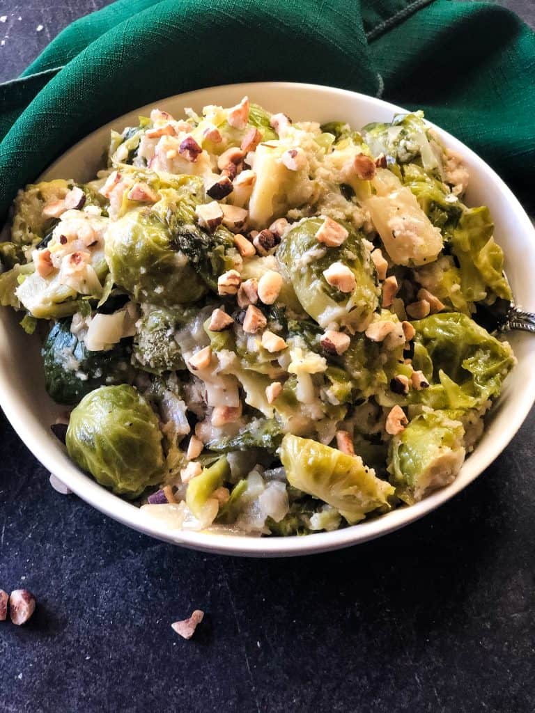 bowl of instant pot brussels sprouts topped with hazelnuts