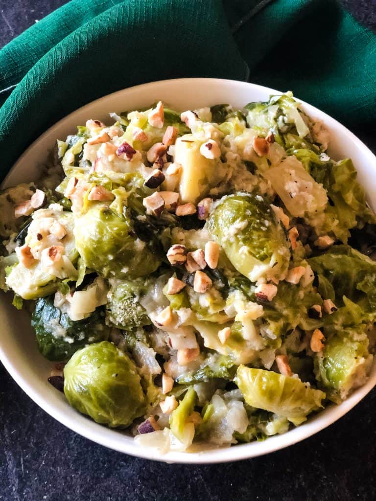 bowl of instant pot brussels sprouts topped with hazelnuts