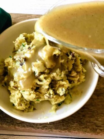 vegan turkey gravy being poured over mashed potatoes