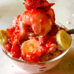 bowl of ice cream with bananas and strawberry topping with pinterest text overlay