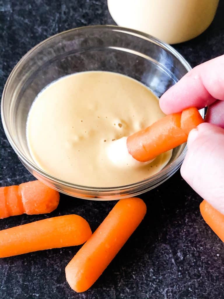 baby carrots dipping in creamy sriracha sauce