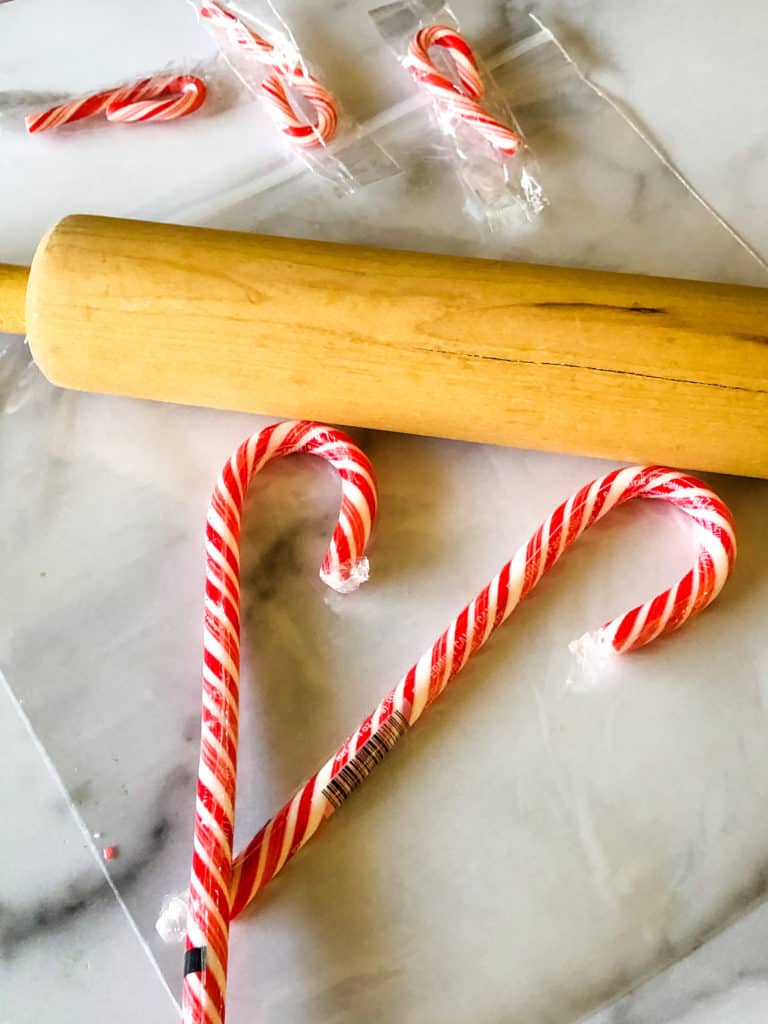 two candy canes and rolling pin on a plastic bag