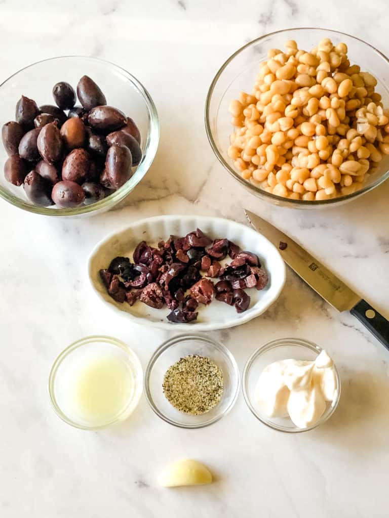 ingredients needed for olive tapenade including kalamata olives, white beans, lemon juice, lemon pepper, and mayo