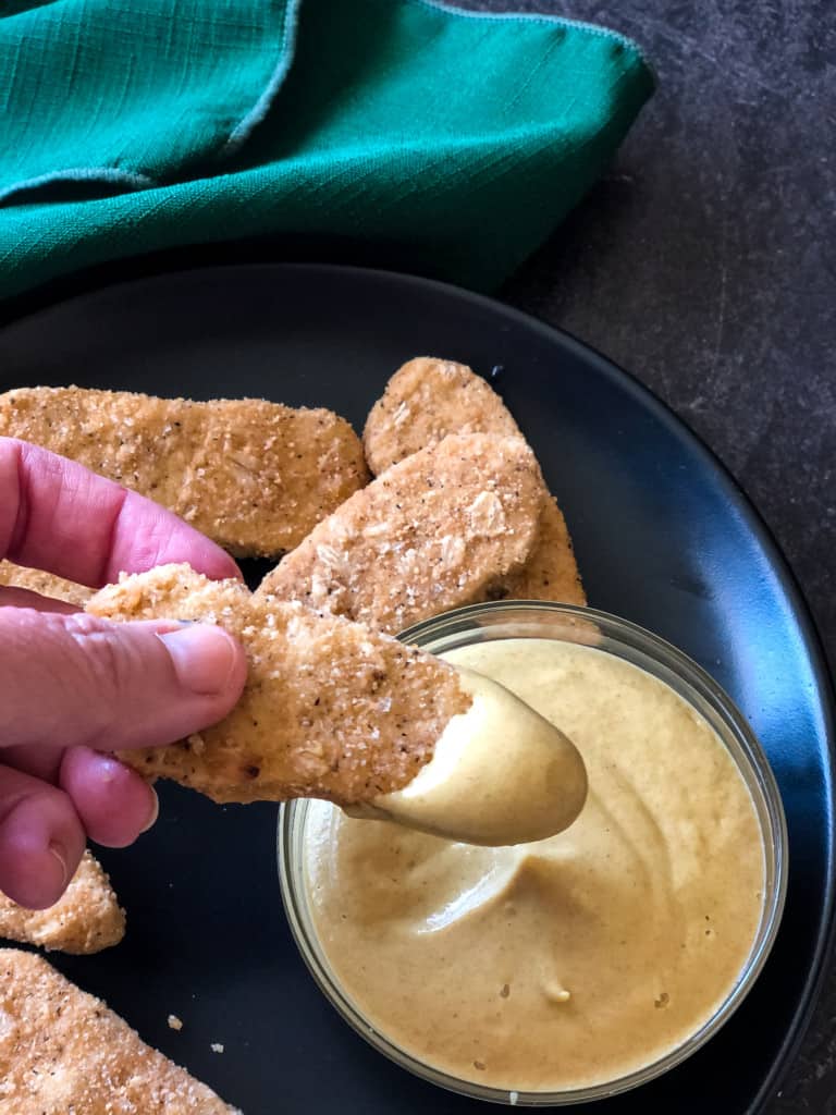 vegan chick nuggets dipped in vegan honey mustard dressing