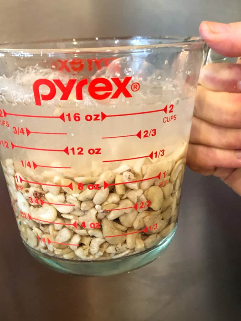cashews in glass pyrex measuring cup soaking in hot water