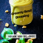 creamy basil dressing in a jar with cashews and basil leaves in the foreground with Pinterest text overlay