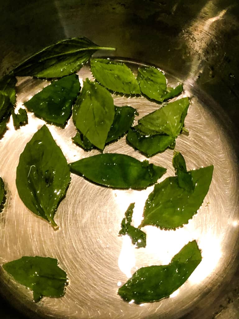 basil leaves in pan with cooked sugar water
