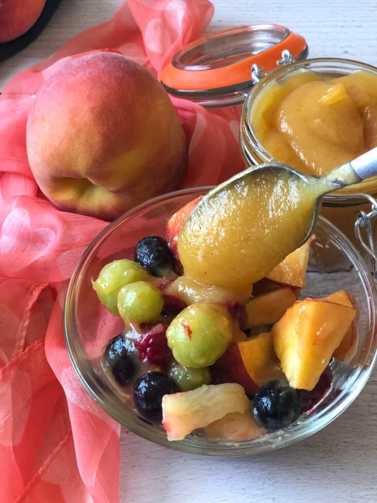 putting peach butter on a bowl of fruit