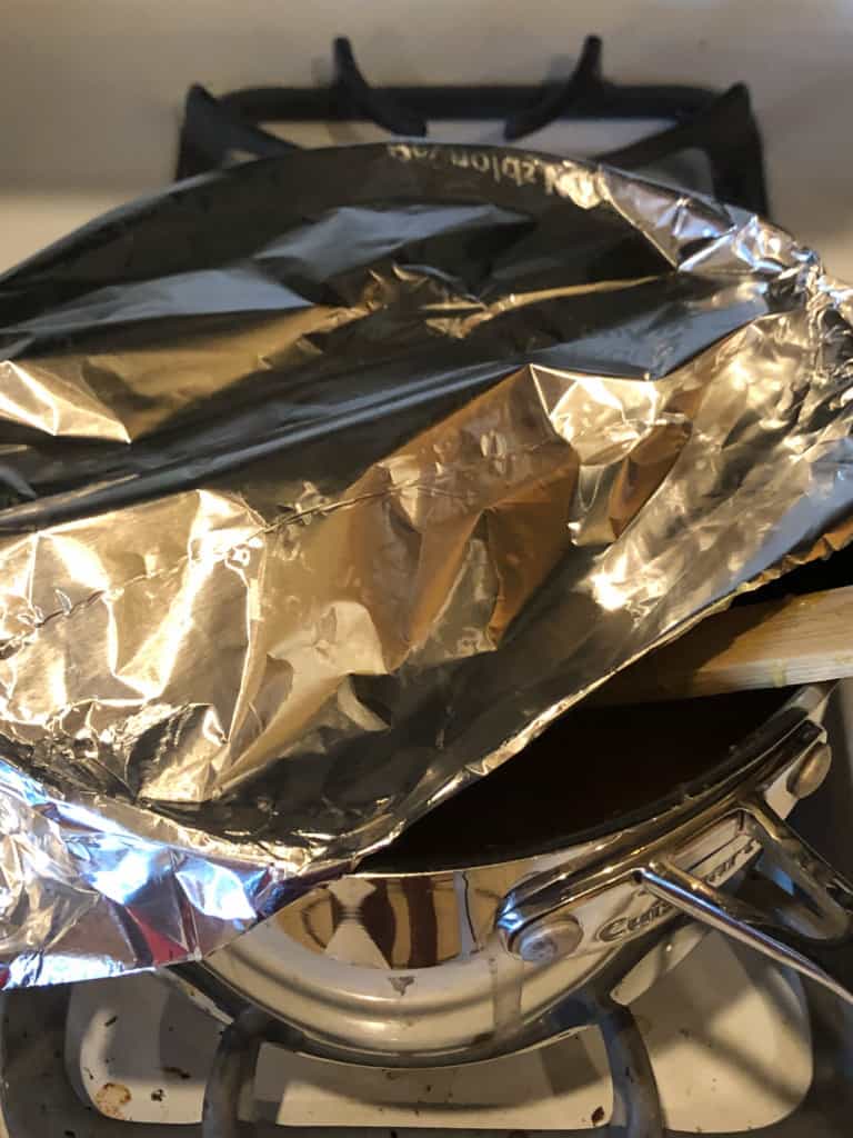 pan cooking peach sauce covered in foil showing how to avoid splatter