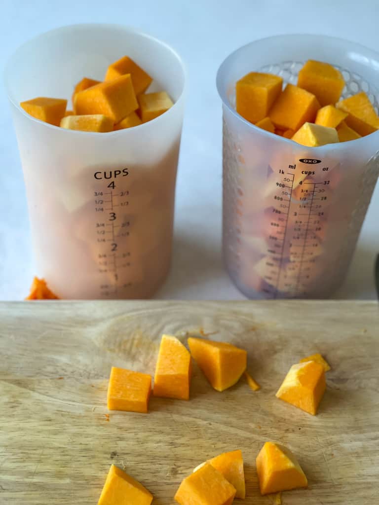 two 4 cup measuring cups showing the amount of cubed squash that one butternut squash yields