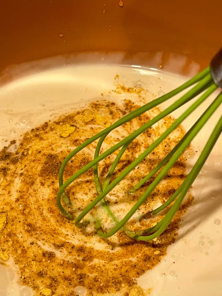 whisking the coconut milk with spices
