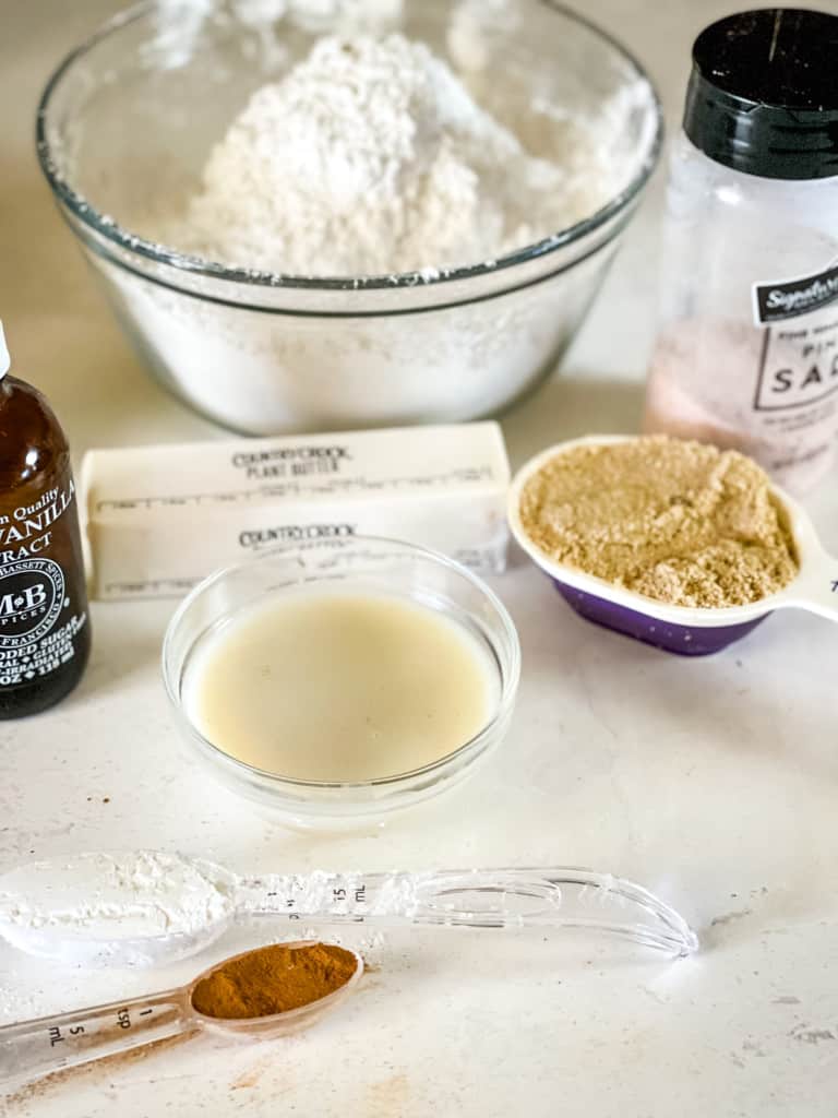 ingredients needed for brown sugar cinnamon glaze including vanilla, oat milk, plant butter, powdered sugar, salt, brown sugar, cornstarch, and cinnamon