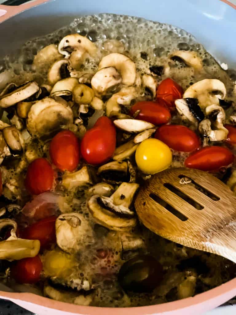 onions, mushrooms, and cherry tomatoes cooking