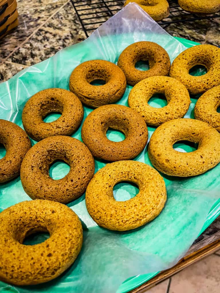 pumpkin donuts on a green platter showing two different batches with color differences