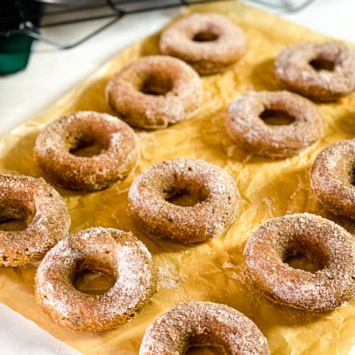sugared pumpkin donuts on parchment paper