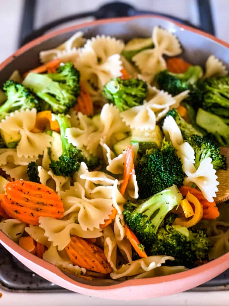 sautéed vegetables and cooked pasta in pan
