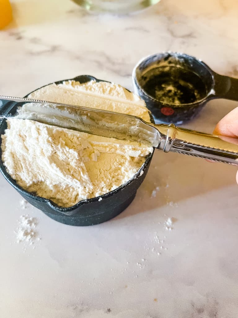 properly measuring flour by leveling the flour with a knife