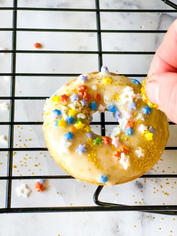 putting sprinkles on the donuts by hand