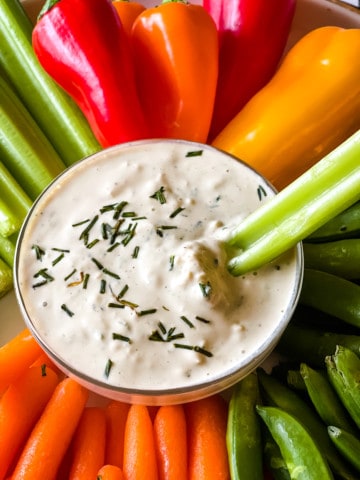 vegan blue cheese dressing with cut veggies with a stick of celery taking a dip